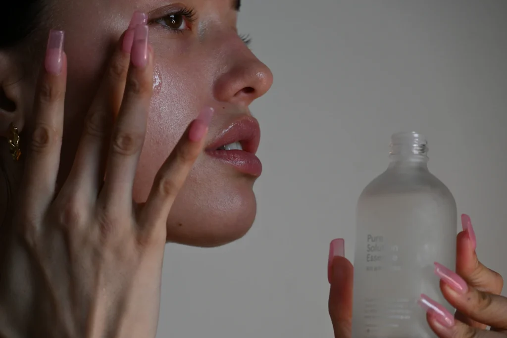 Woman applying skincare for acne treatment - benzoyl peroxide 2.5% vs 5%
